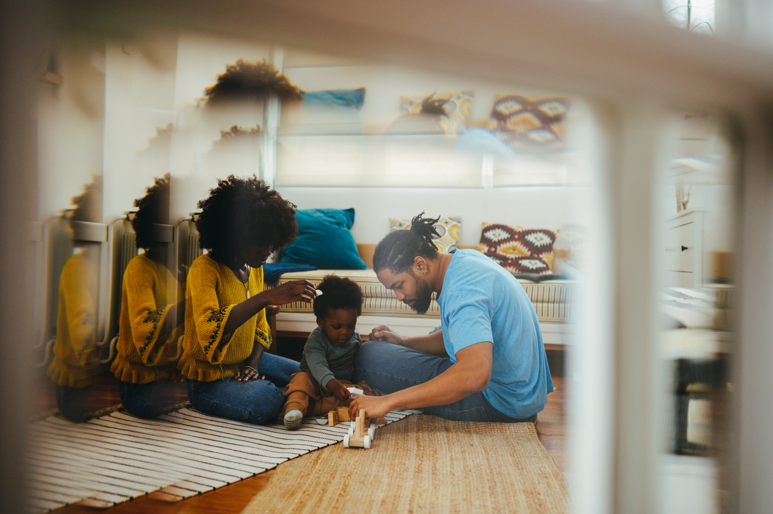 Adults playing with a young child on the floor at home
